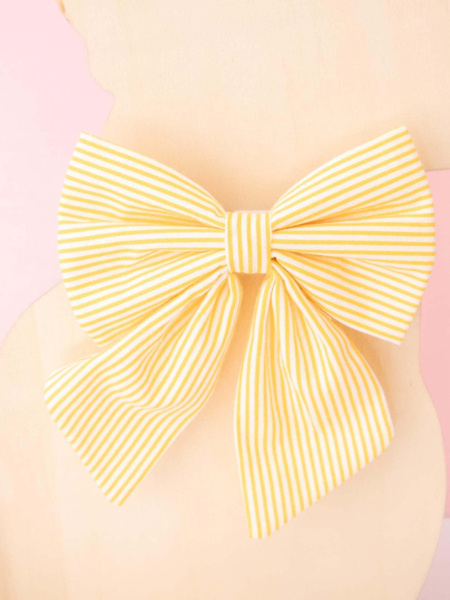 Large yellow bow on a pink background