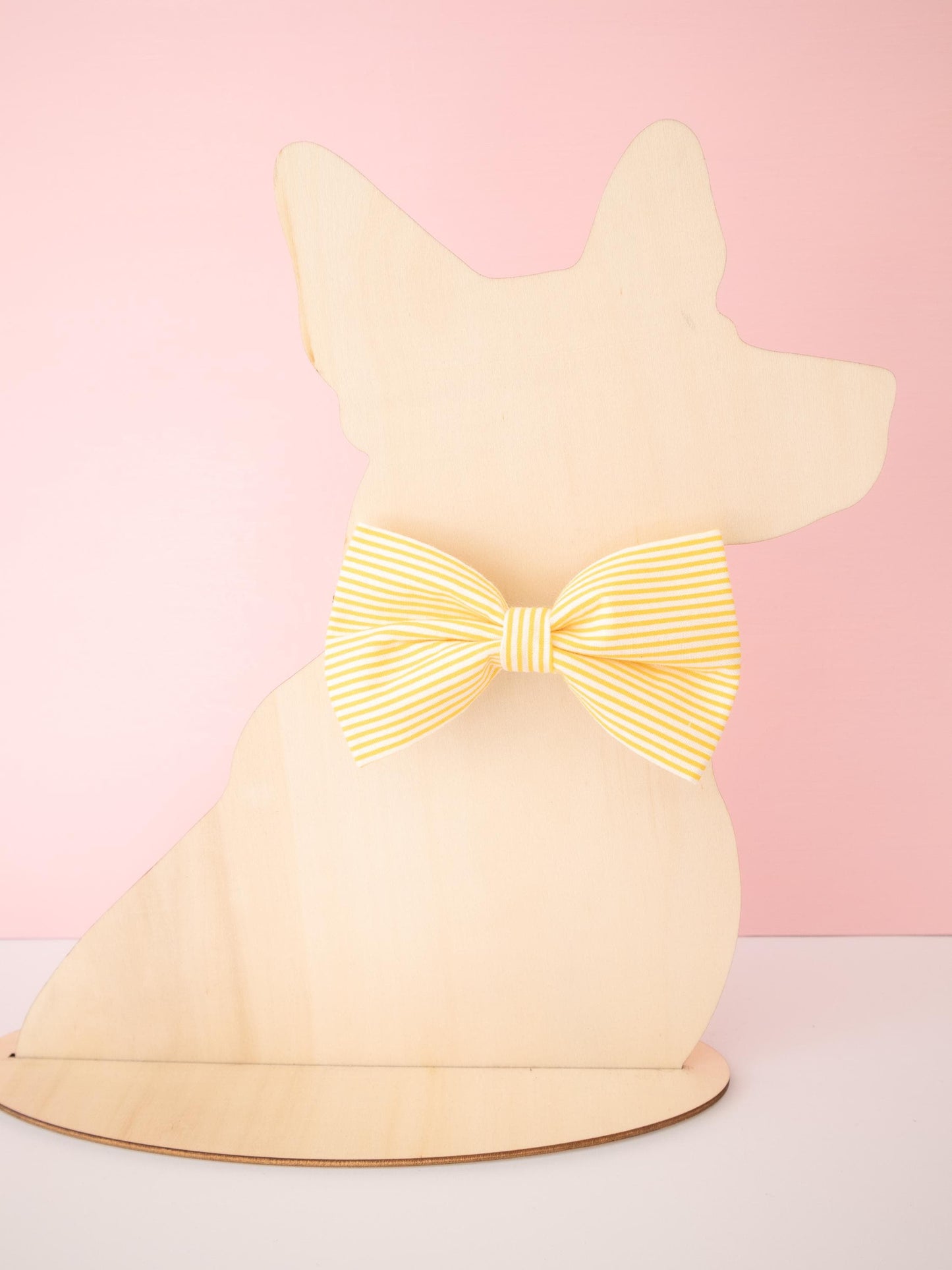 Dog-shaped model with a glowing yellow bow on a pink background