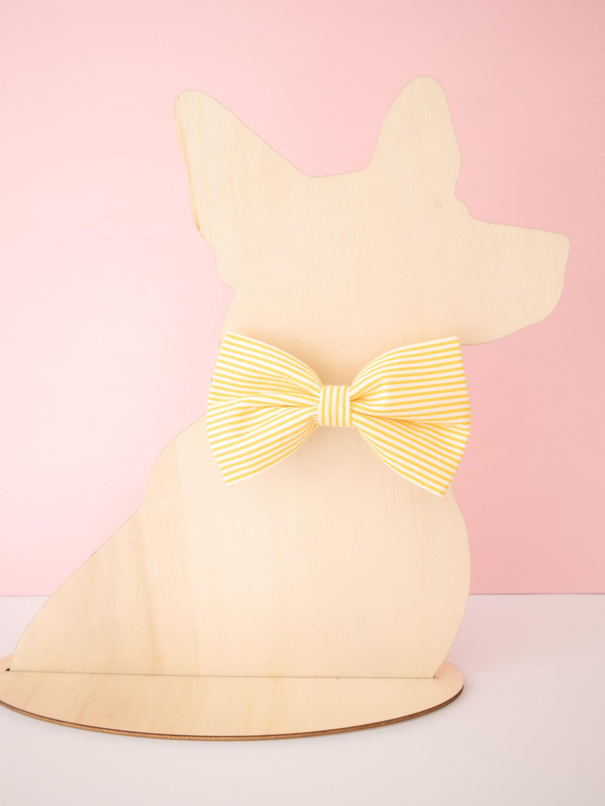 Dog-shaped model with a glowing yellow bow on a pink background