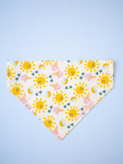 Dog bandana with smiling sun pattern on a light blue background