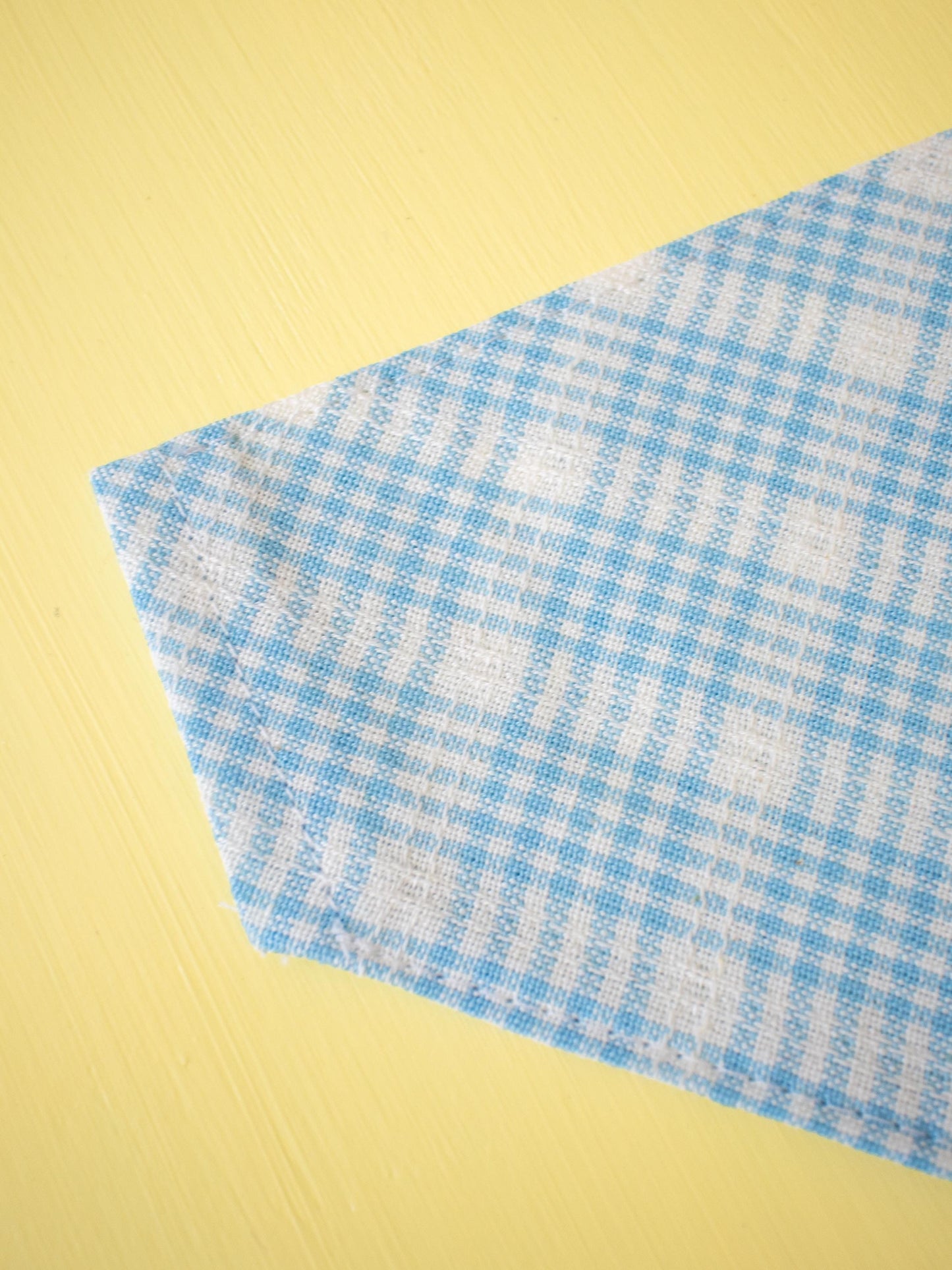 Blue and white checkered fabric on a yellow background
