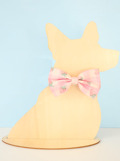 Yellow dog-shaped model with a pink bow on a light blue background