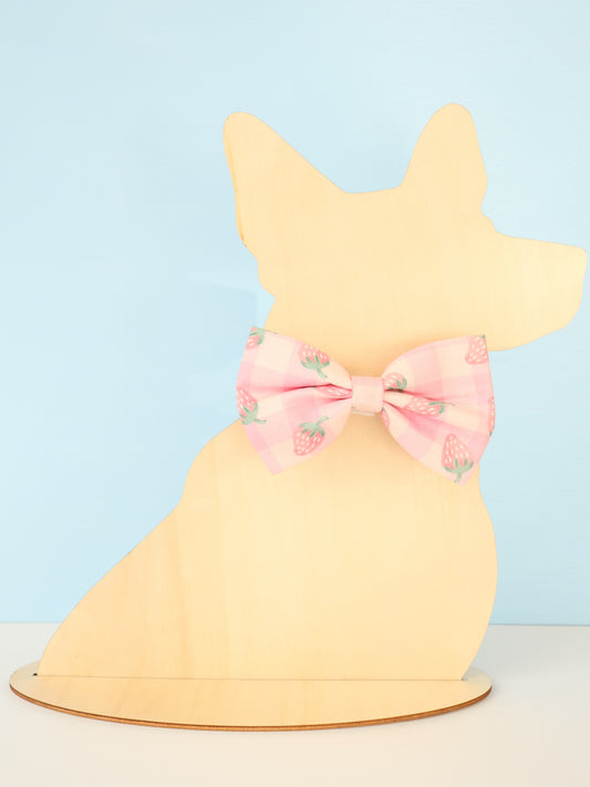 Yellow dog-shaped model with a pink bow on a light blue background