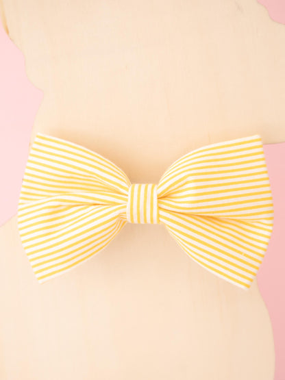 Yellow striped bow on a pink background