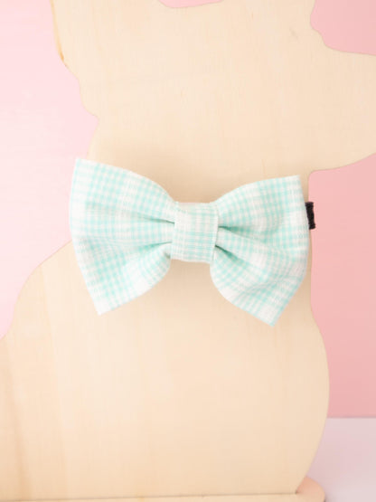 Pastel checkered bow tie on a pink and beige background