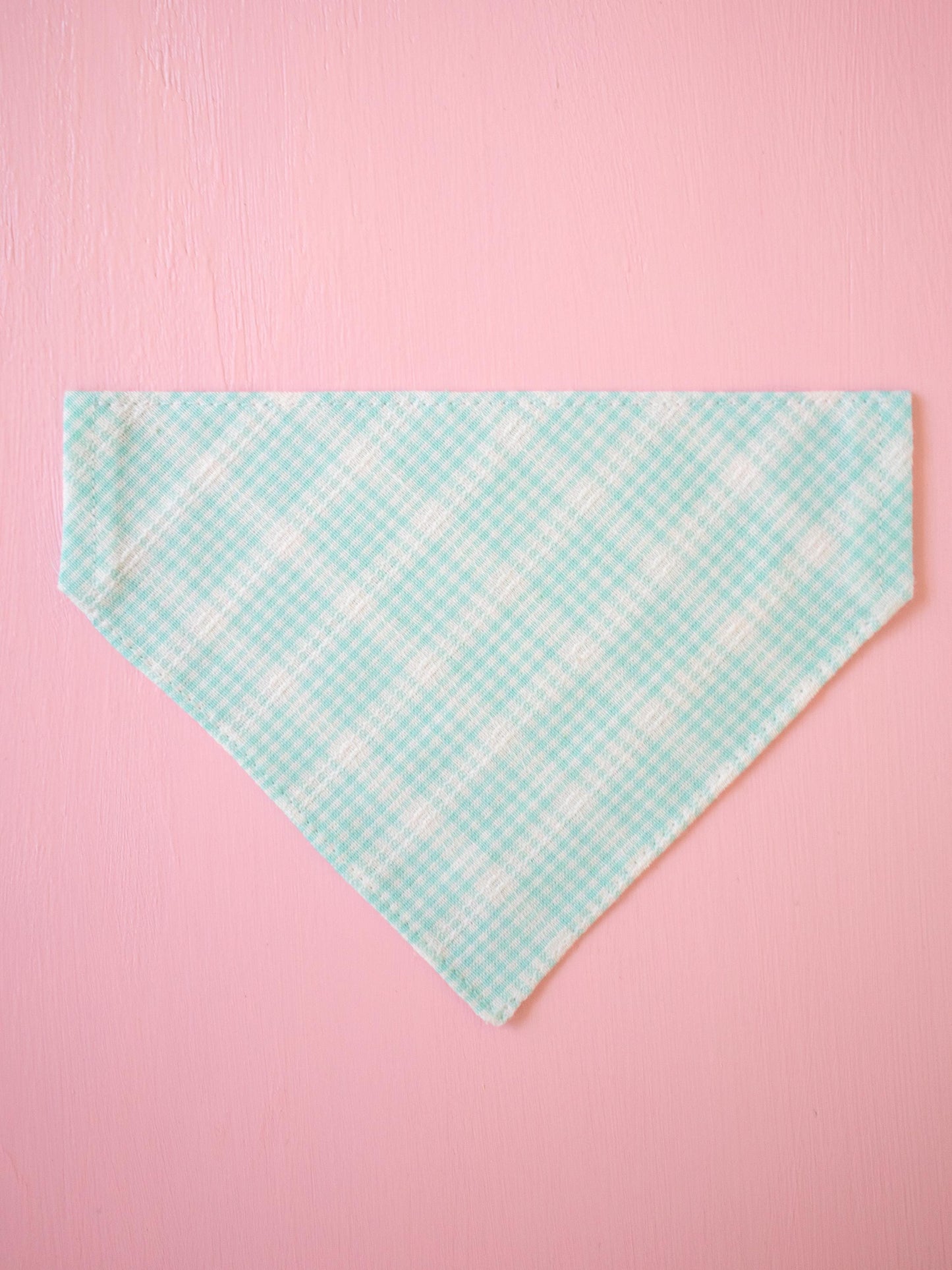 Teal checkered bandana on a pink background