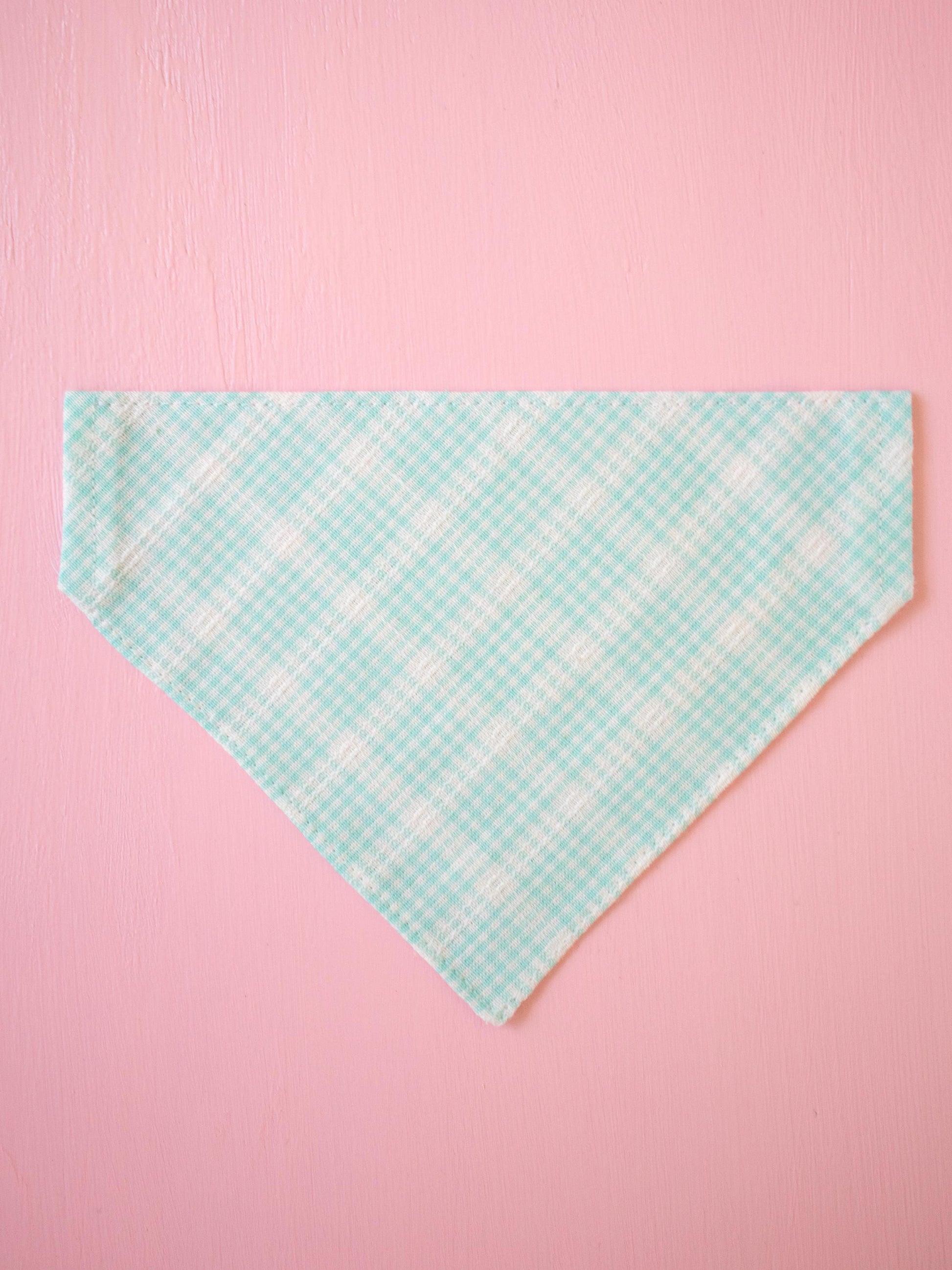 Teal checkered bandana on a pink background