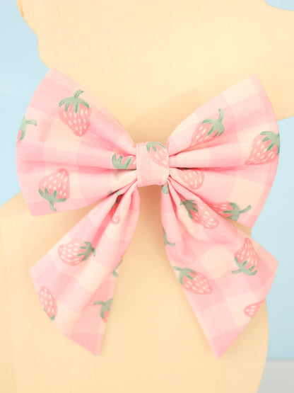 Pink bow with strawberry pattern on a pastel background