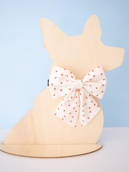 Dog-shaped Mannequin with a white sailor bow featuring red hearts on a light blue background