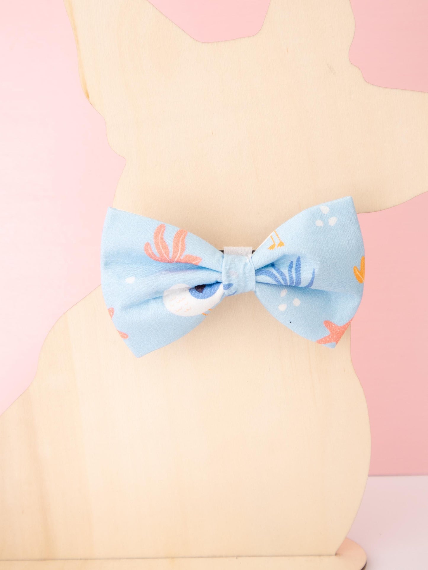 Light blue bow tie with seagull character pattern on a pastel background