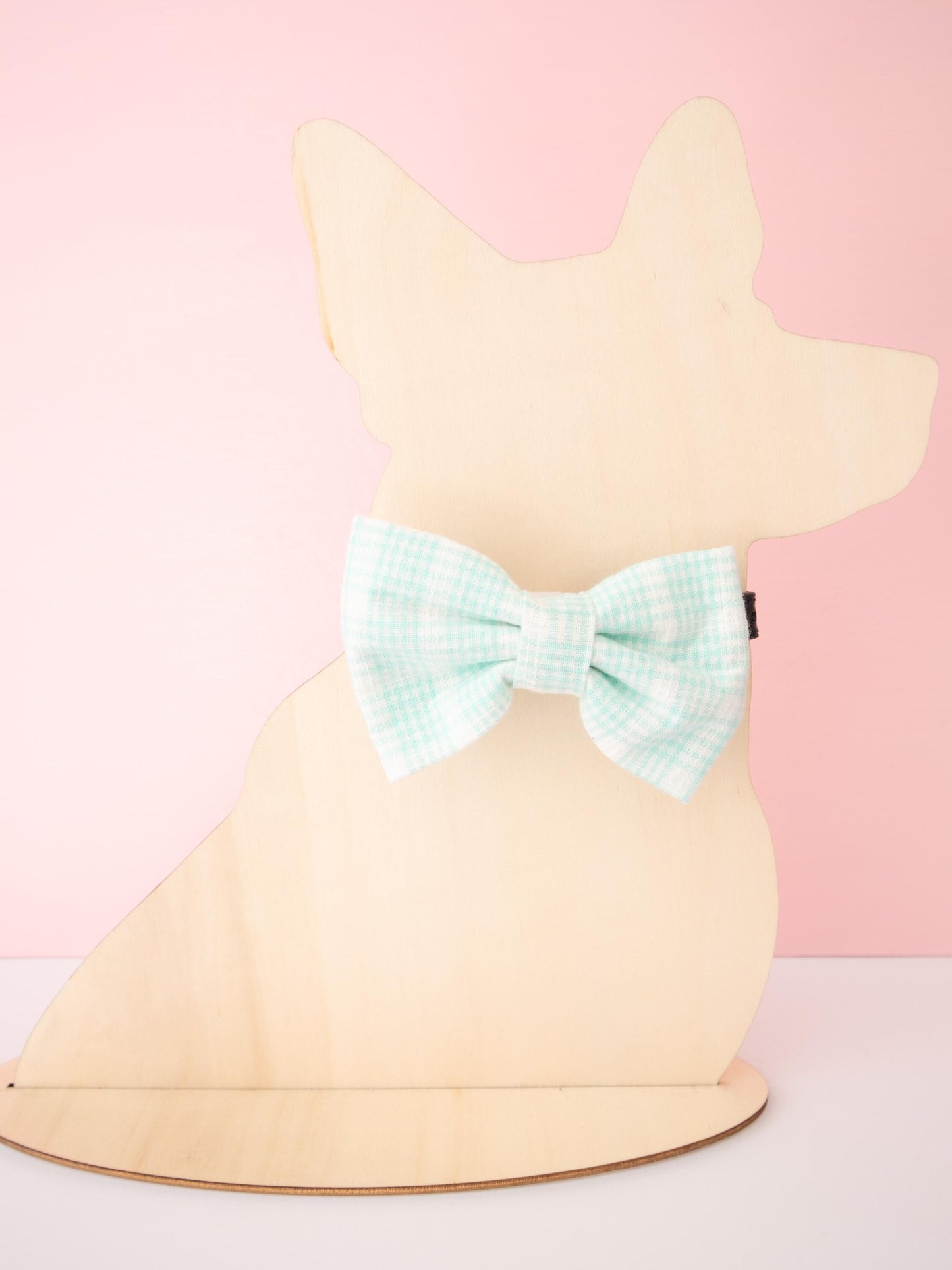 Mannequin dog wearing a bow on a pink background