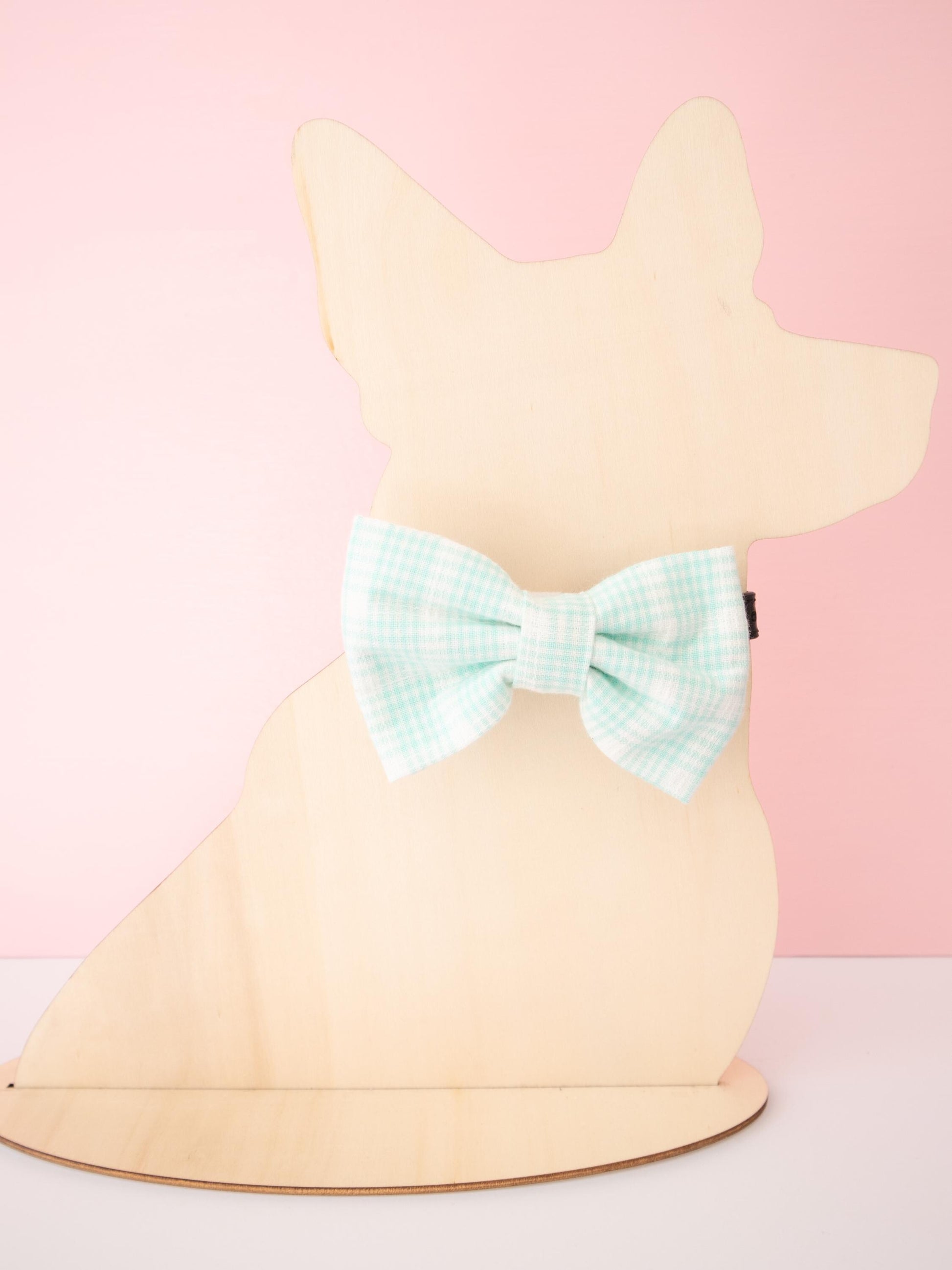 Mannequin dog wearing a bow on a pink background