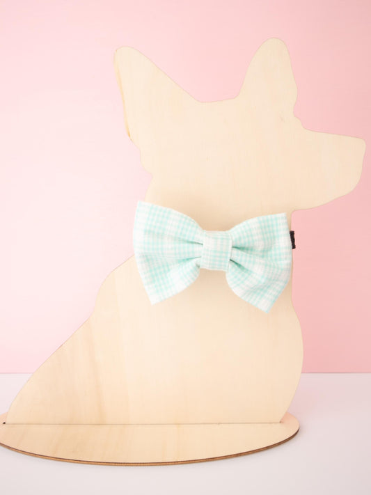 Mannequin dog wearing a bow on a pink background