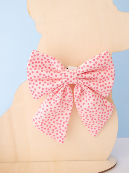 Mannequin wearing a pink polka dot bow on a light blue background