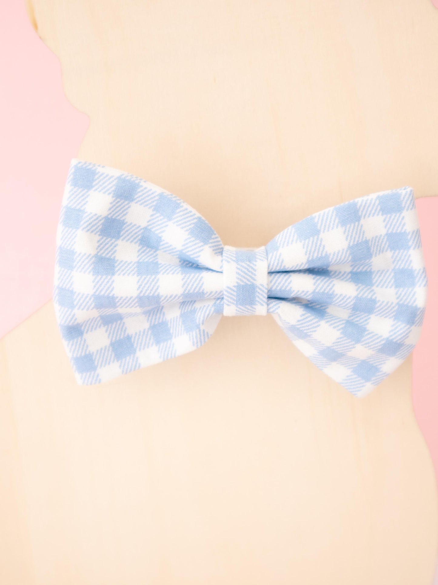 Blue and white checkered bow tie on a beige background