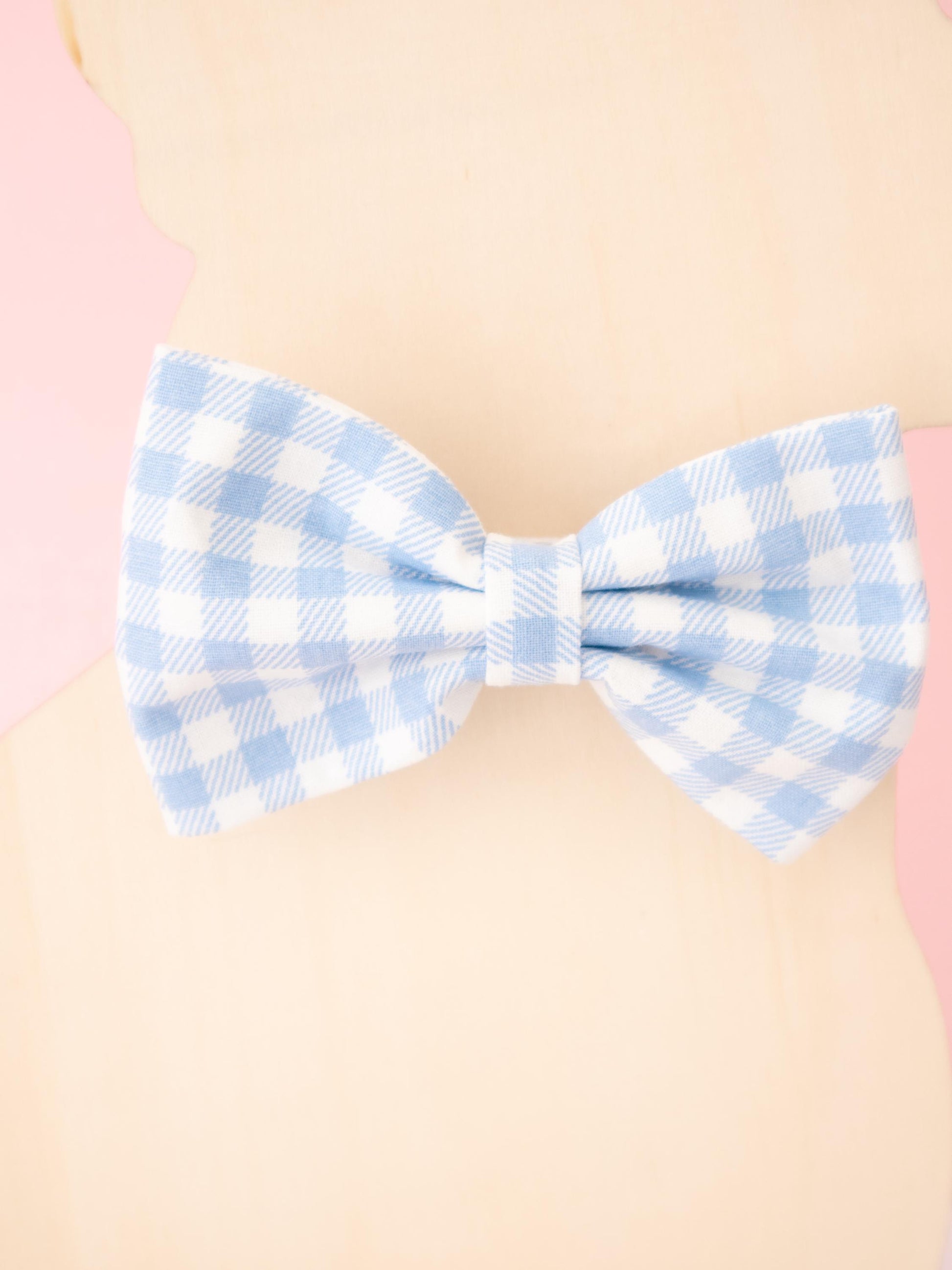 Blue and white checkered bow tie on a beige background