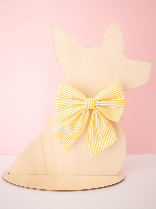 Dog-shaped model with a large yellow bow on a pink background