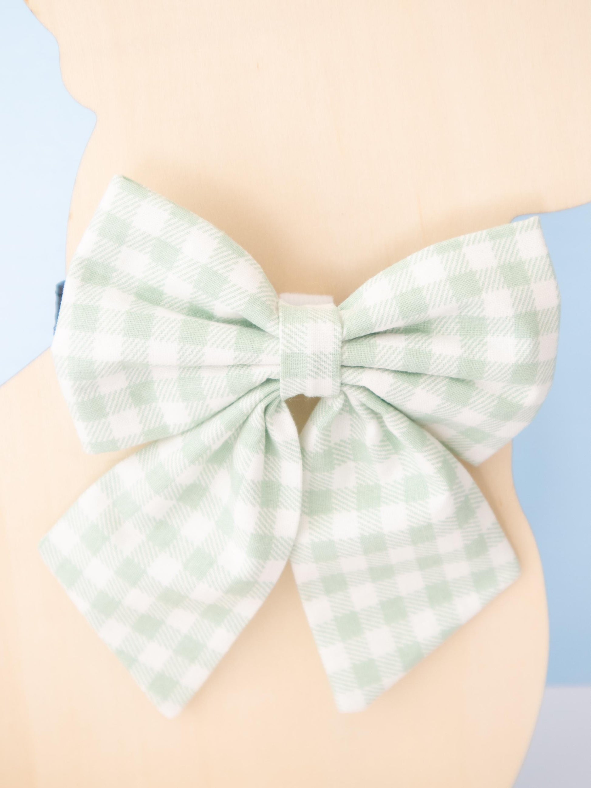 Green checkered bow on a Mannequin against a light blue background