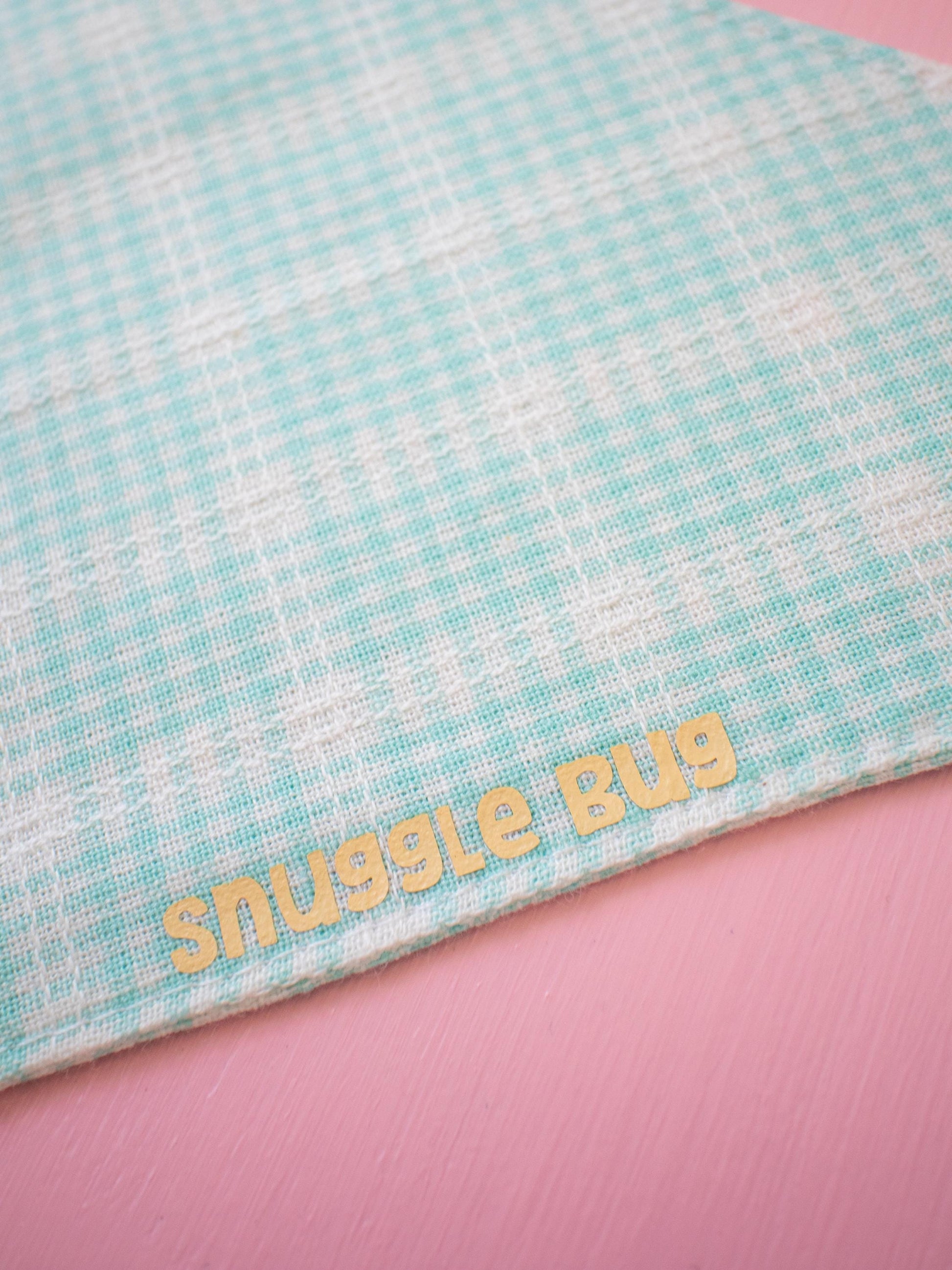 Bandana with 'snuggle bug' text on a pink background