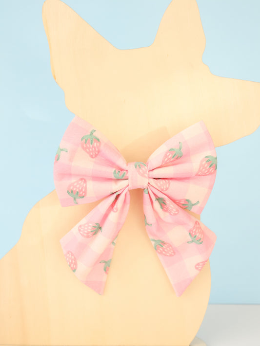 Pastel yellow dog model with a pink bow and strawberry pattern on a light blue background