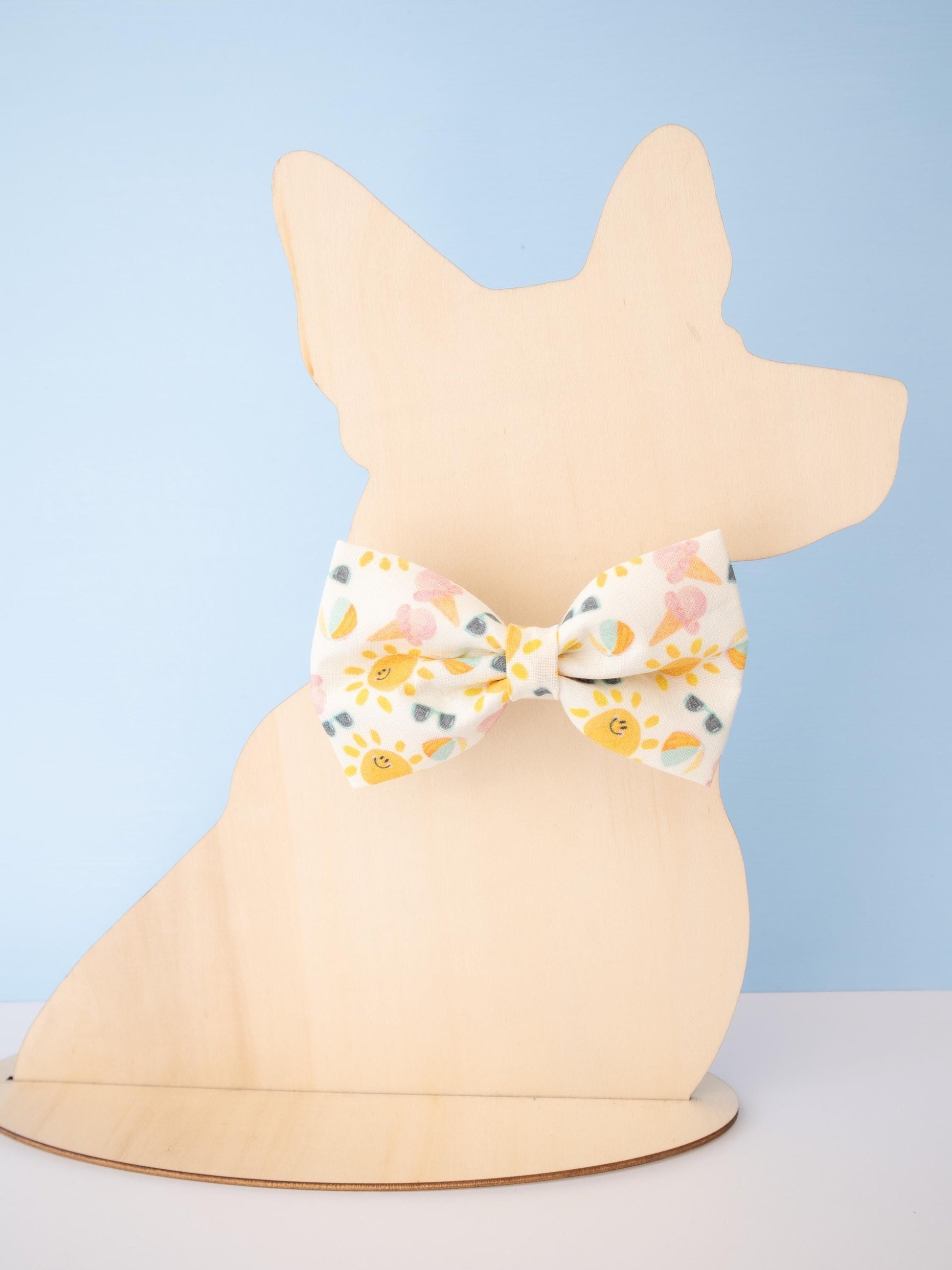 Dog figurine wearing a patterned bow tie against a light blue background