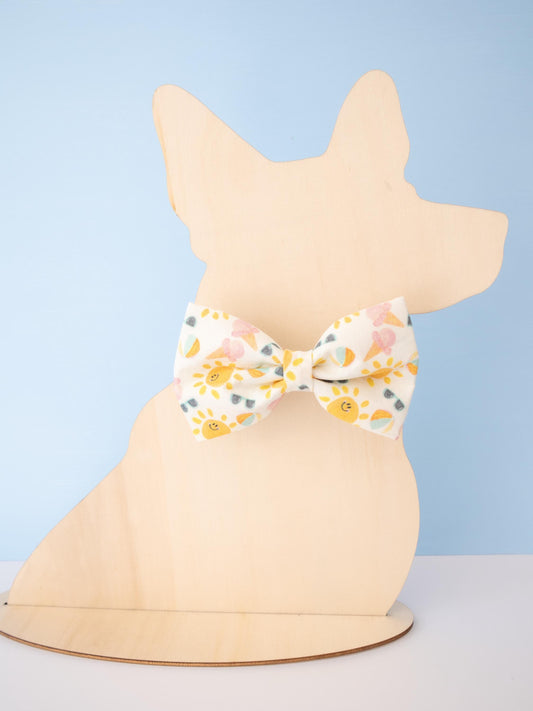 Dog figurine wearing a patterned bow tie against a light blue background