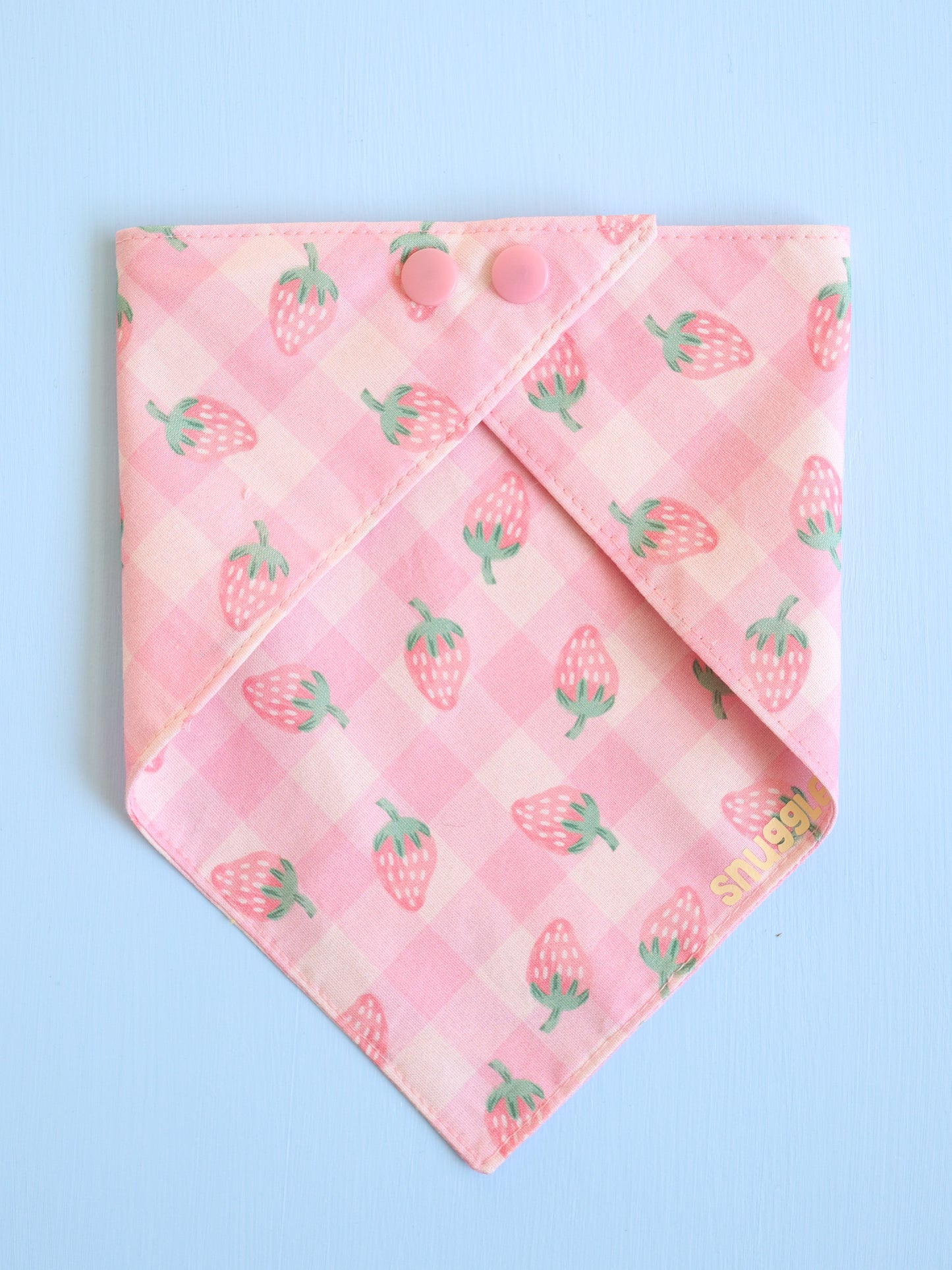 Pink bandana with strawberry pattern on a light blue background