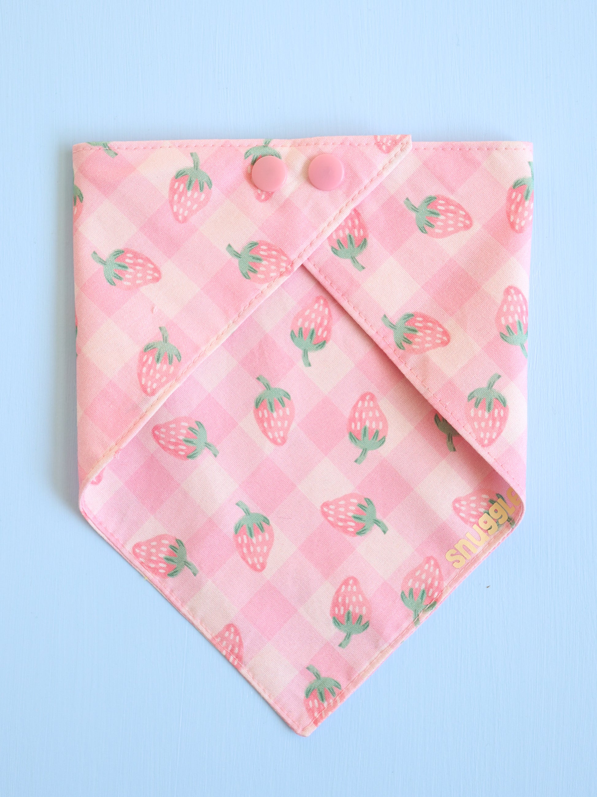 Pink bandana with strawberry pattern on a light blue background
