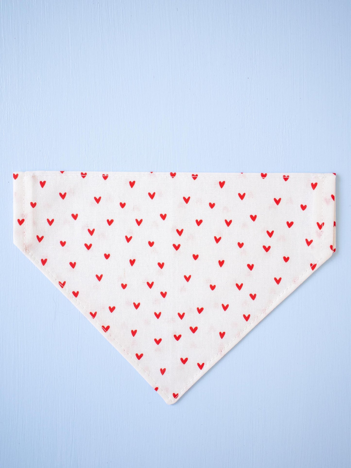 White Dog bandana with red heart pattern on a light blue background