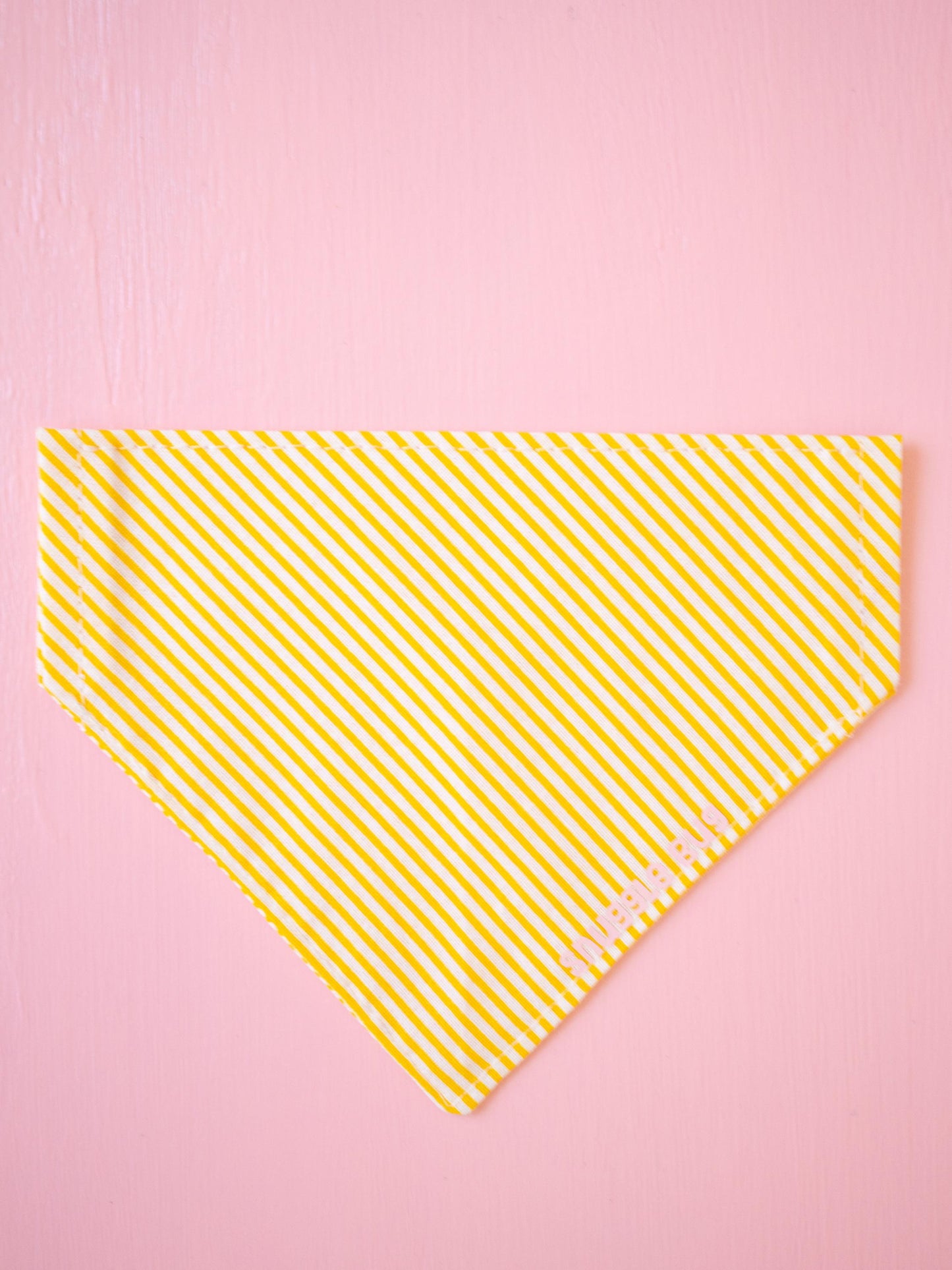 Yellow striped bandana on a pink background