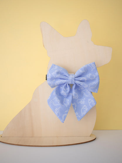 Blue sailor bow on a mannequin dog head against a yellow background
