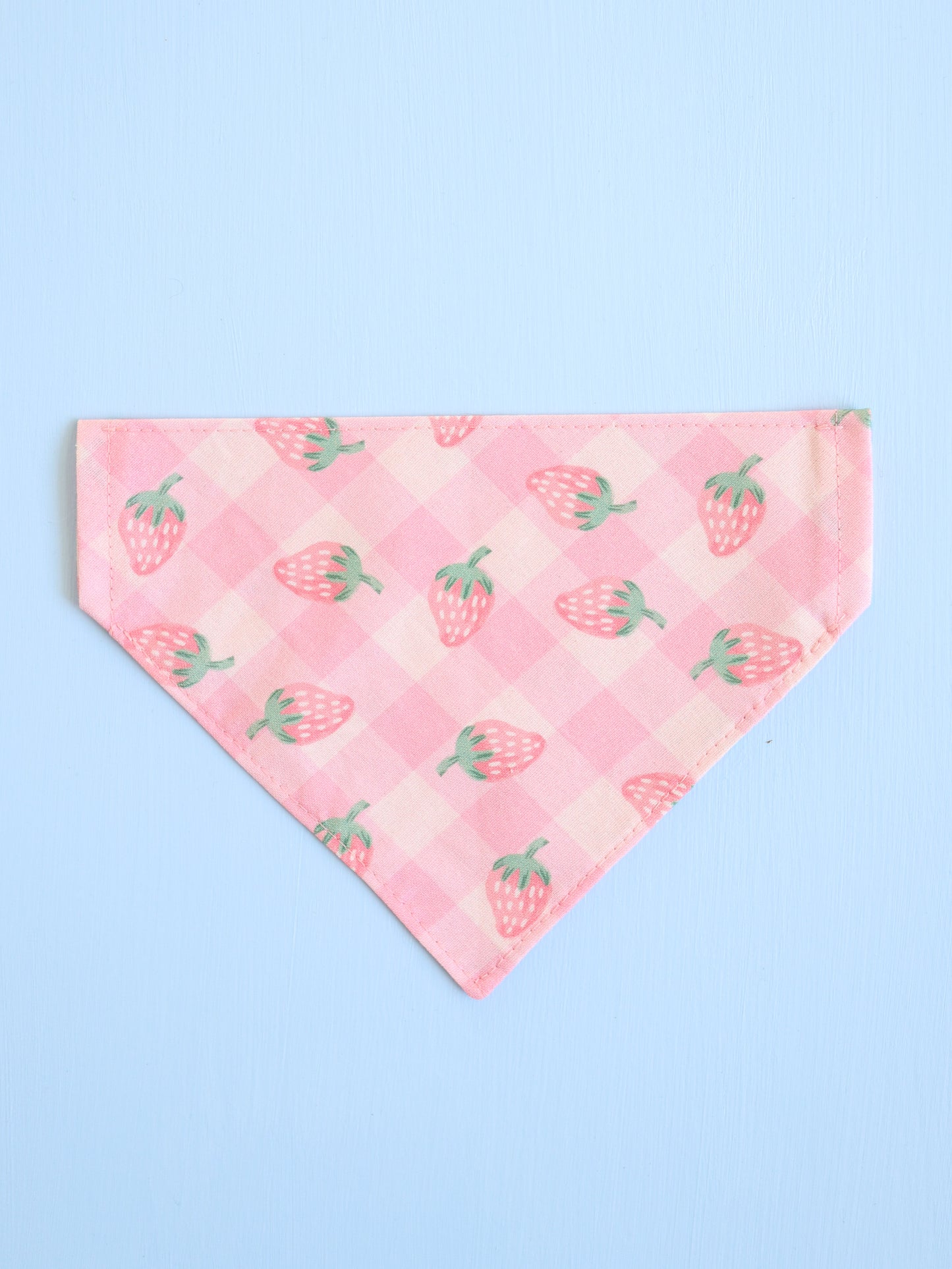 Pink bandana with strawberry pattern on a light blue background