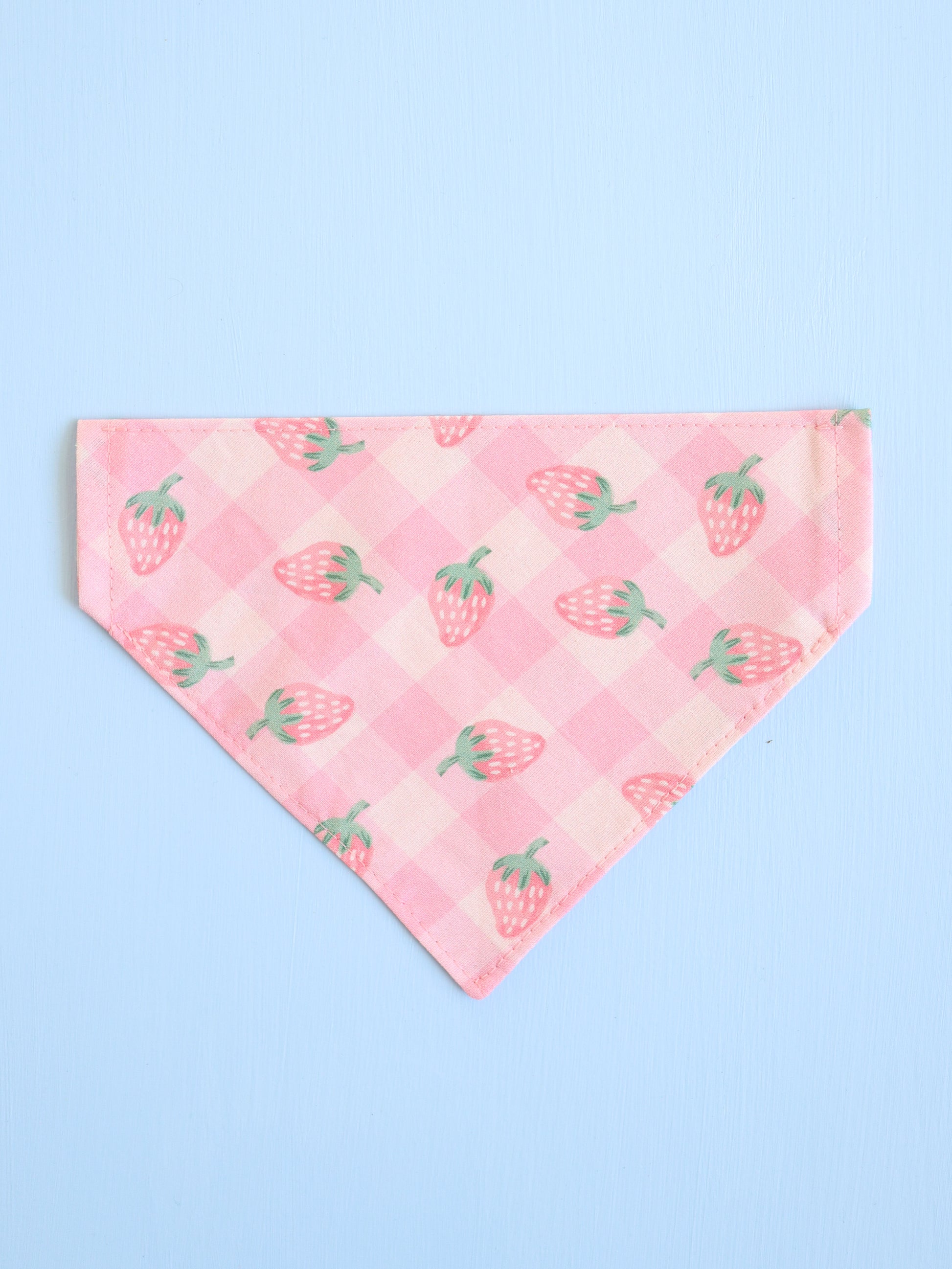 Pink bandana with strawberry pattern on a light blue background