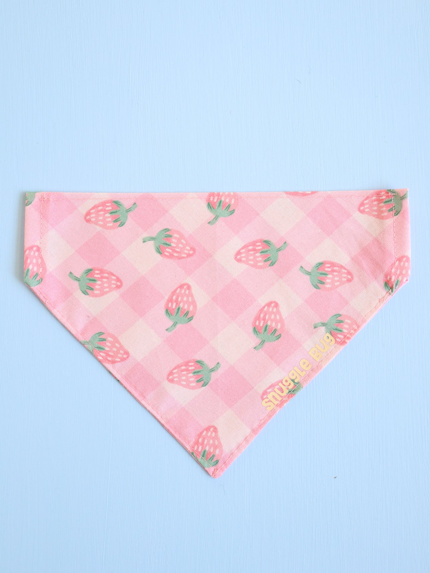 Pink bandana with strawberry pattern on a light blue background