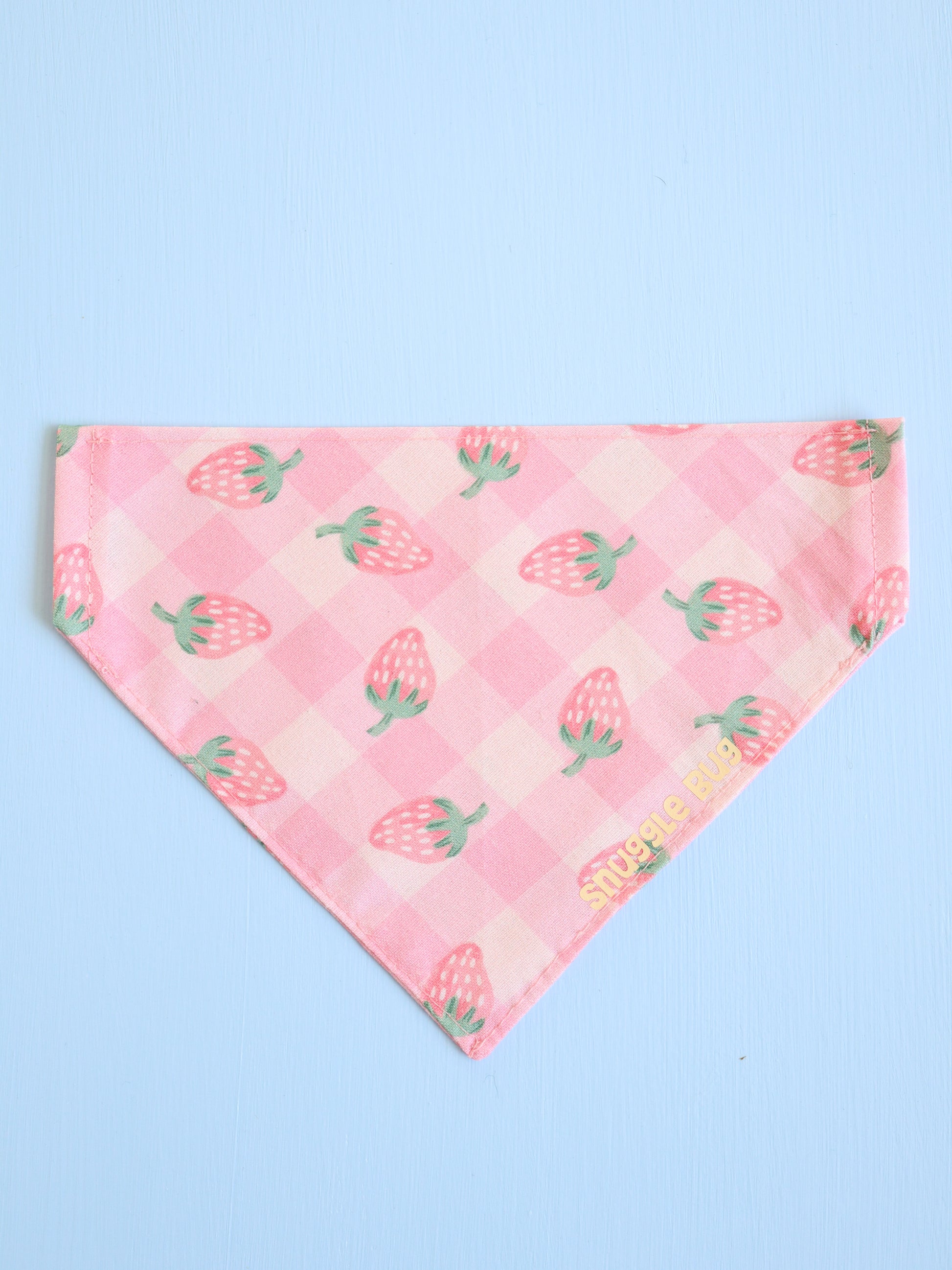 Pink bandana with strawberry pattern on a light blue background