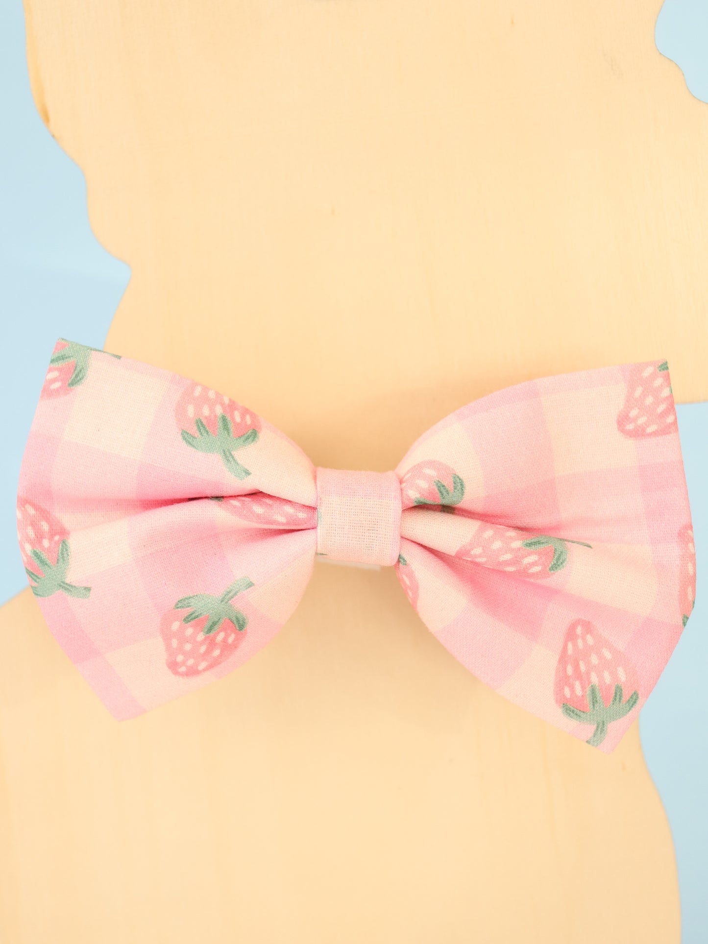 Pink bow with strawberry pattern on a pastel background