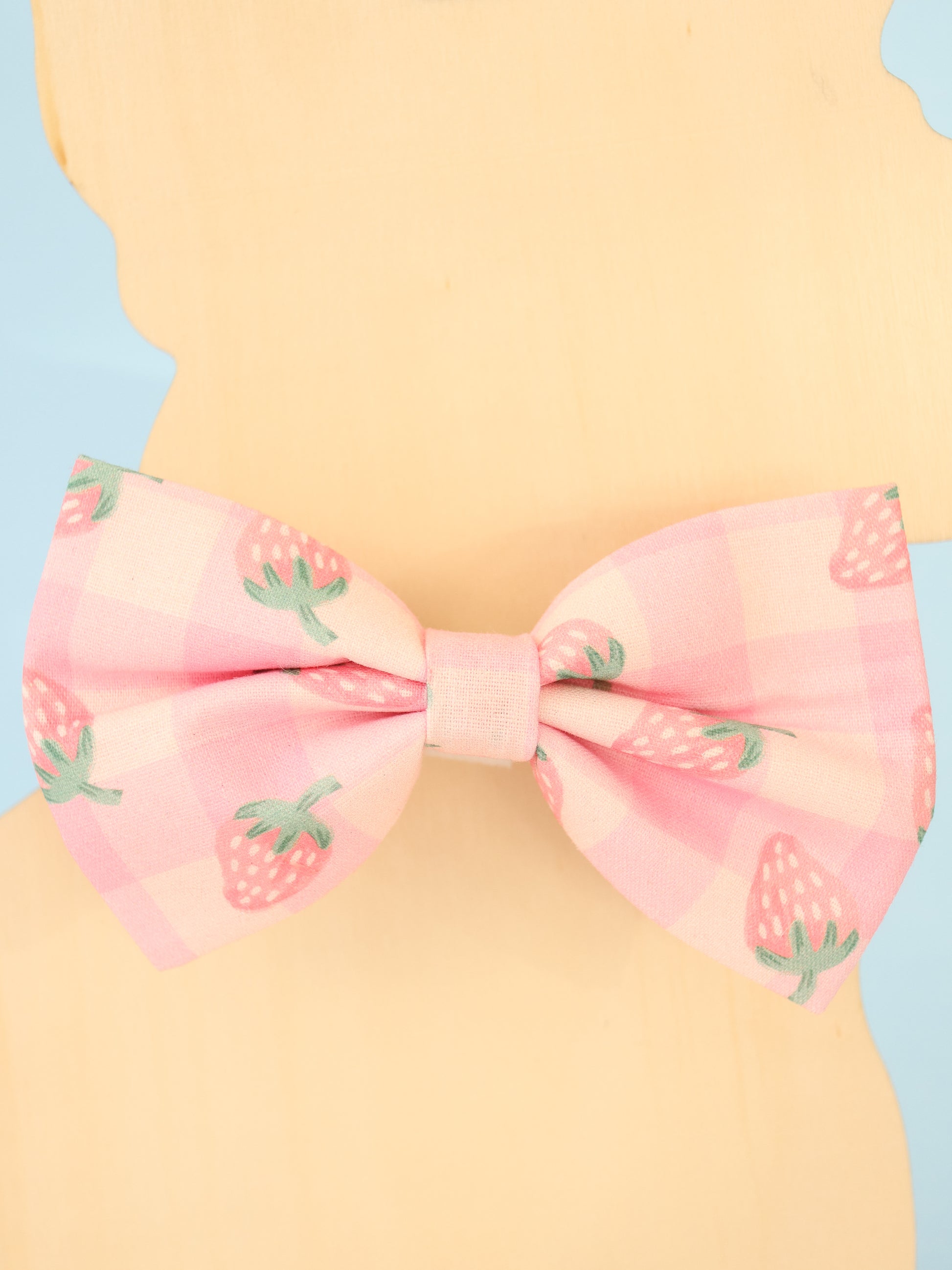 Pink bow with strawberry pattern on a pastel background