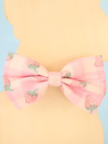 Pink bow with strawberry pattern on a pastel background