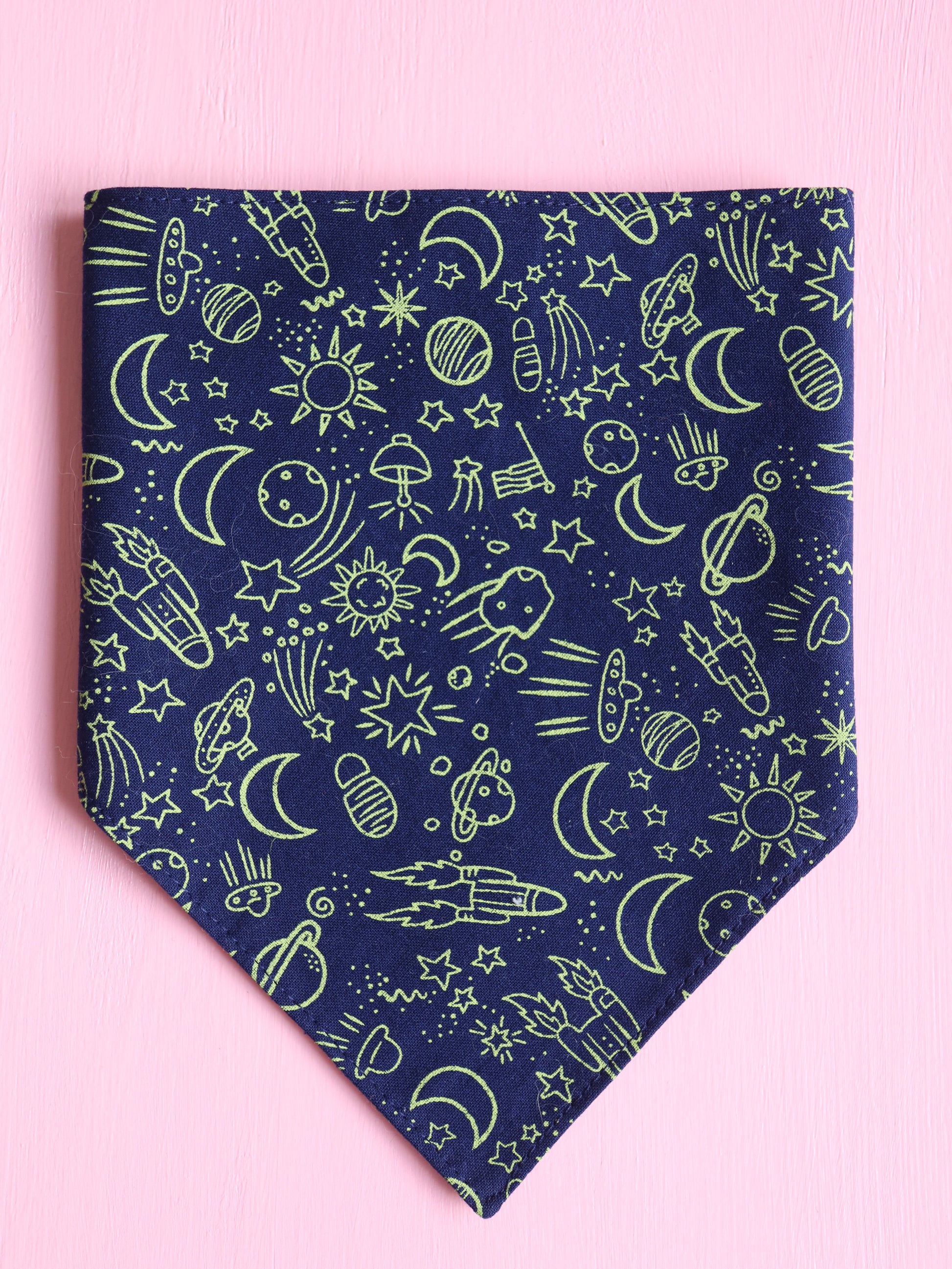 Navy blue bandana with green space-themed pattern on a pink background