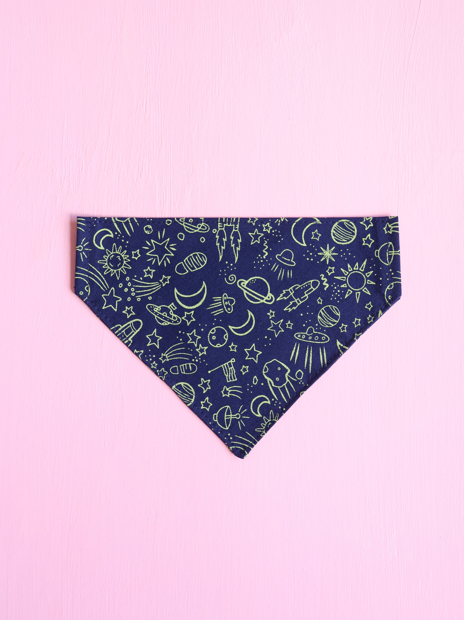 Navy blue bandana with green space-themed pattern on a pink background