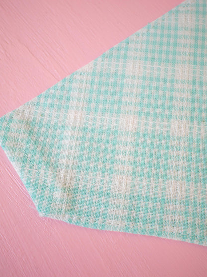 Teal checkered fabric on a pink background