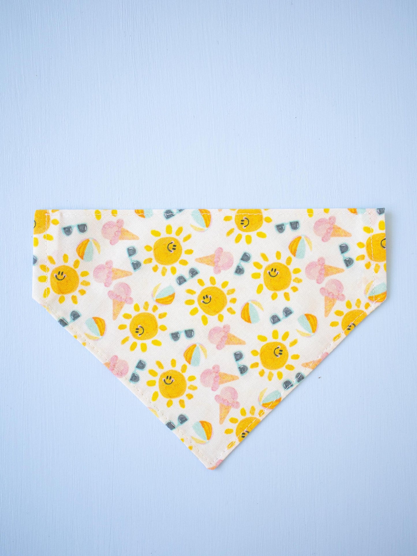 Smiling sun patterned bandana on a light blue background