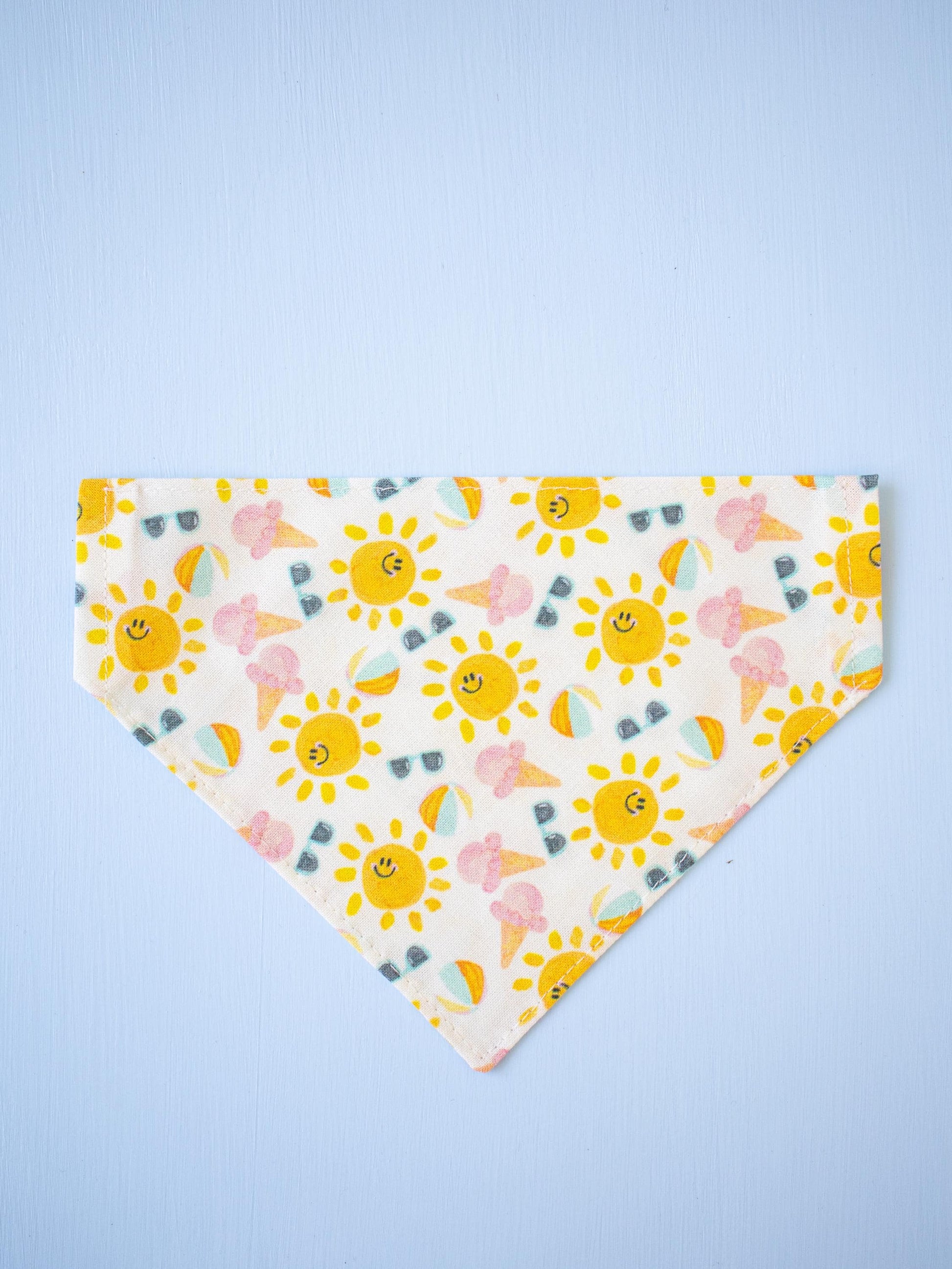 Smiling sun patterned bandana on a light blue background