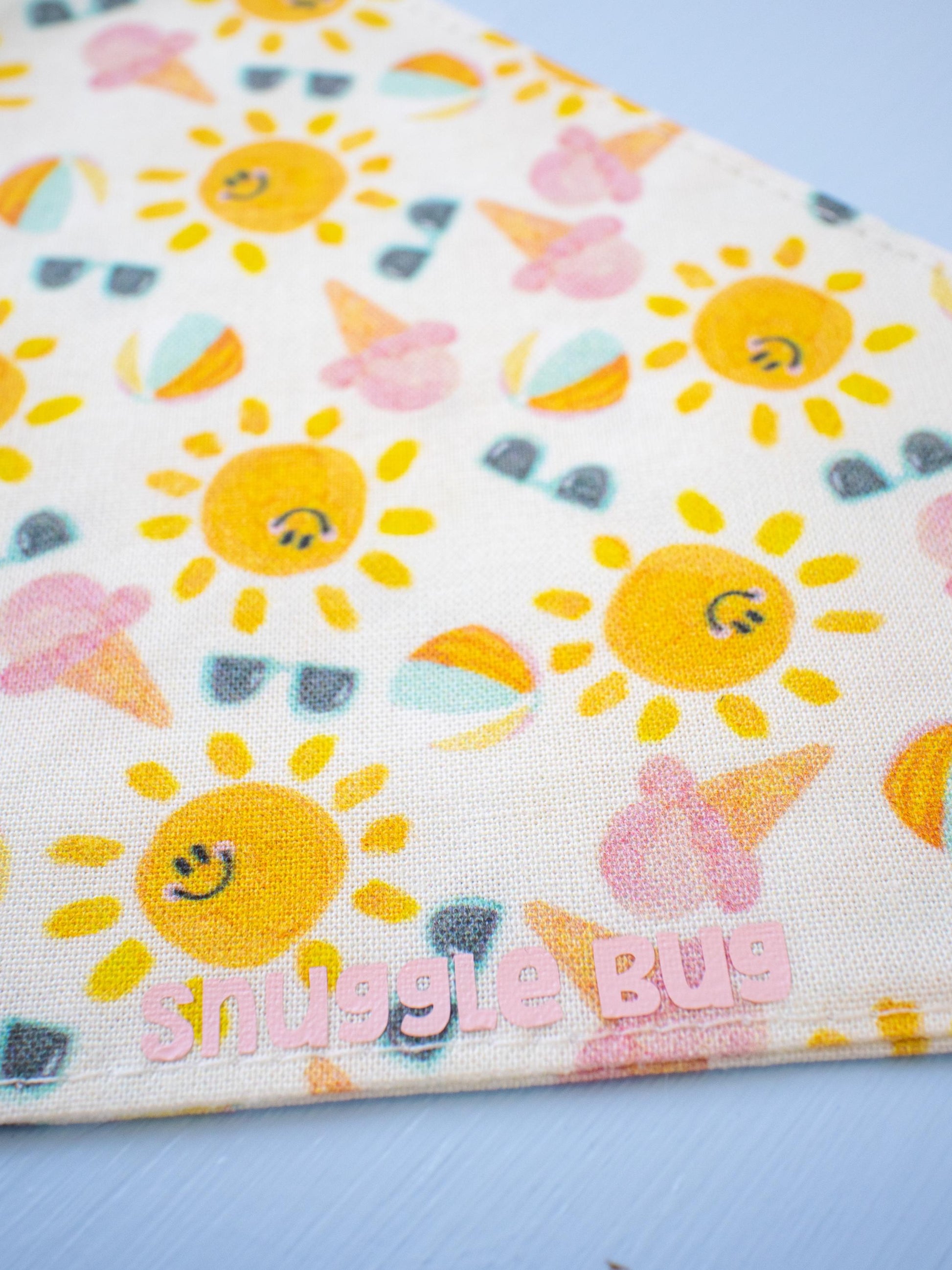 Fabric with sun and ice cream pattern and 'smiggle bug' branding on a blue background