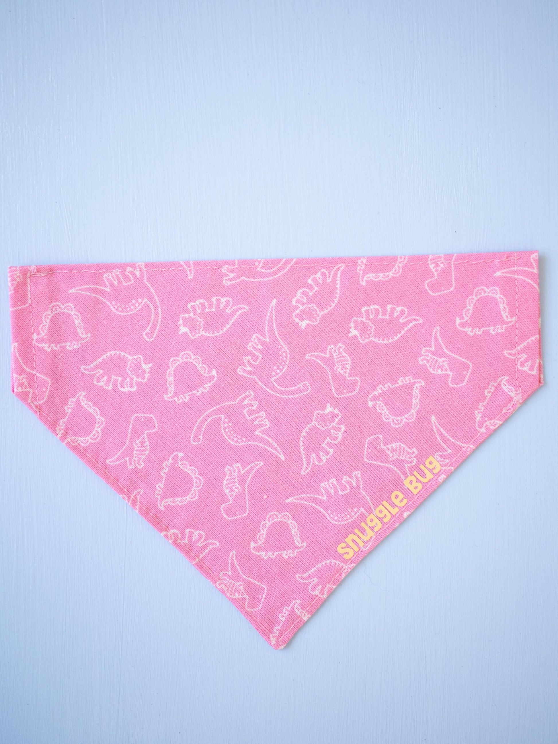 Pink bandana with white dinosaur pattern on a light blue background