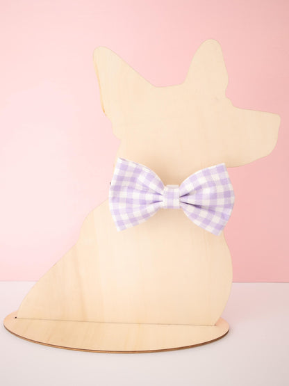 Dog-shaped Mannequin with a purple checkered bow on a pink background