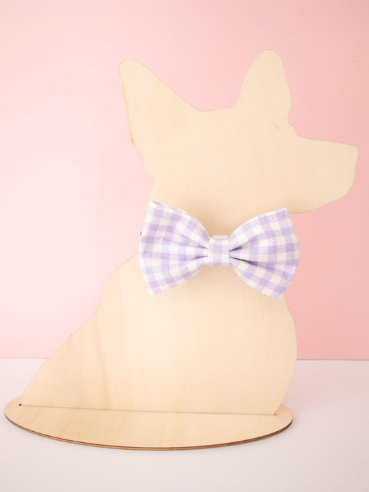 Dog-shaped Mannequin with a purple checkered bow on a pink background