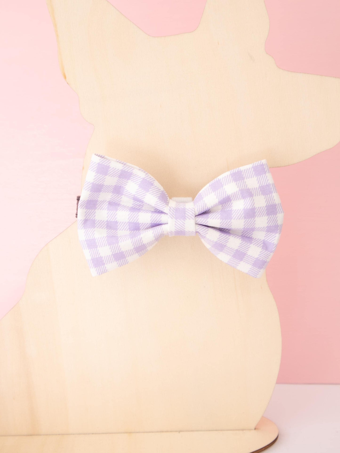 Dog Mannequin with a purple and white checkered bow on a pink background