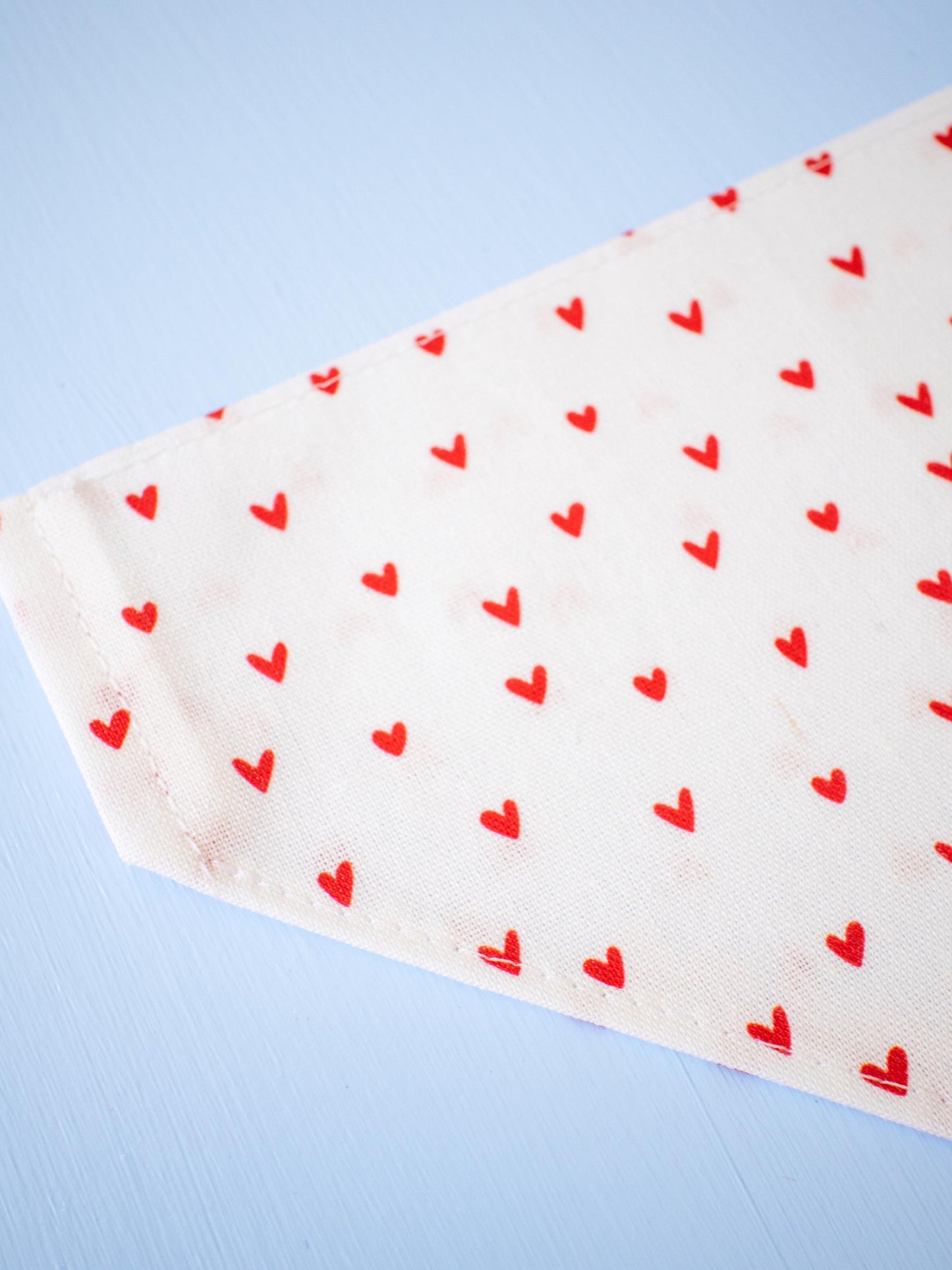 White fabric with red heart patterns on a light blue background