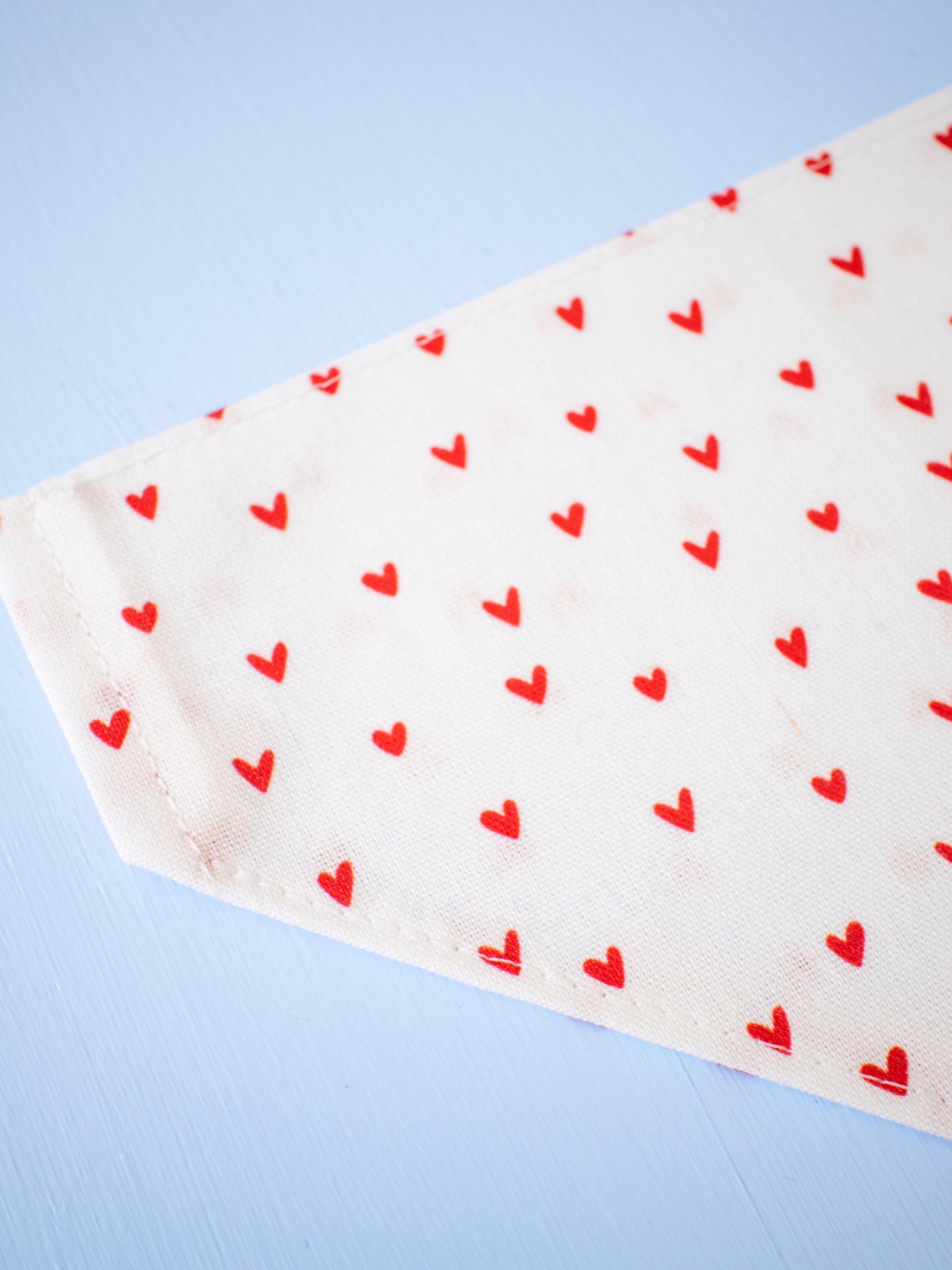 White fabric with red heart patterns on a light blue background